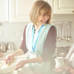 femme aidant un senior à faire la vaisselle. Aide ménagère.