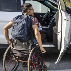 Un étudiant en fauteuil roulant monte à bord d'une voiture.