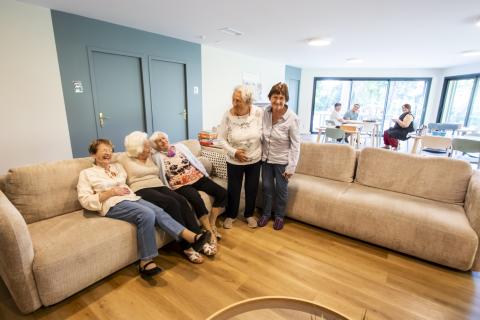 personnes âgées riant sur un canapé