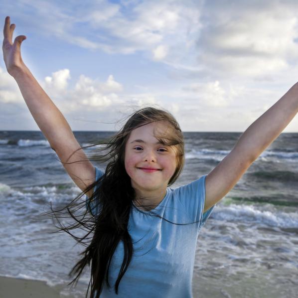 Une jeune fille trisomique s'amuse à la plage