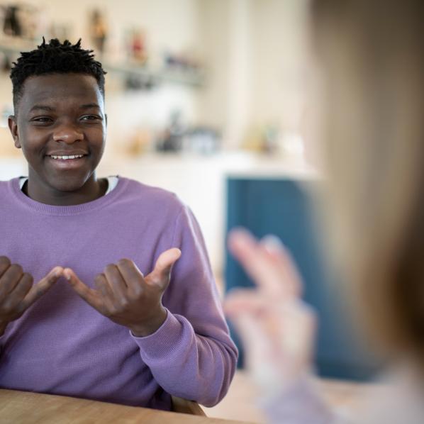 Un jeune homme discute avec une femme en langue des signes 