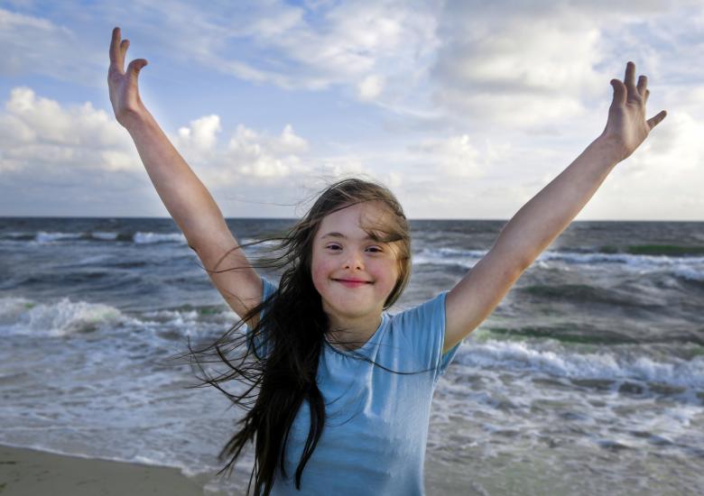 Une jeune fille trisomique s'amuse à la plage