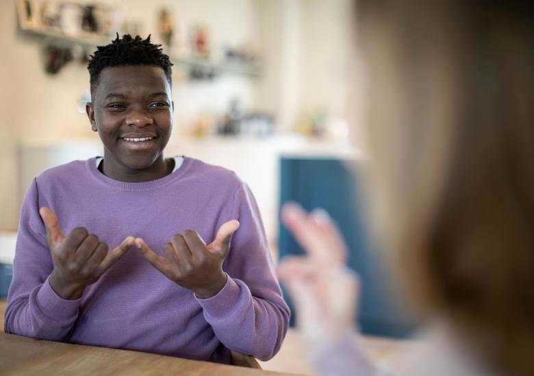 Un jeune homme discute avec une femme en langue des signes 