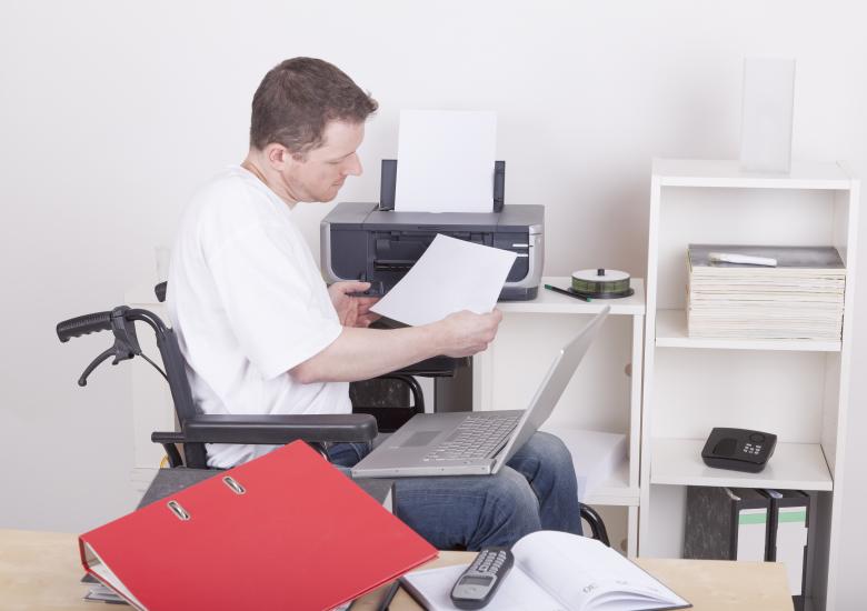 un homme en fauteuil roulant fait un point sur ses dossiers